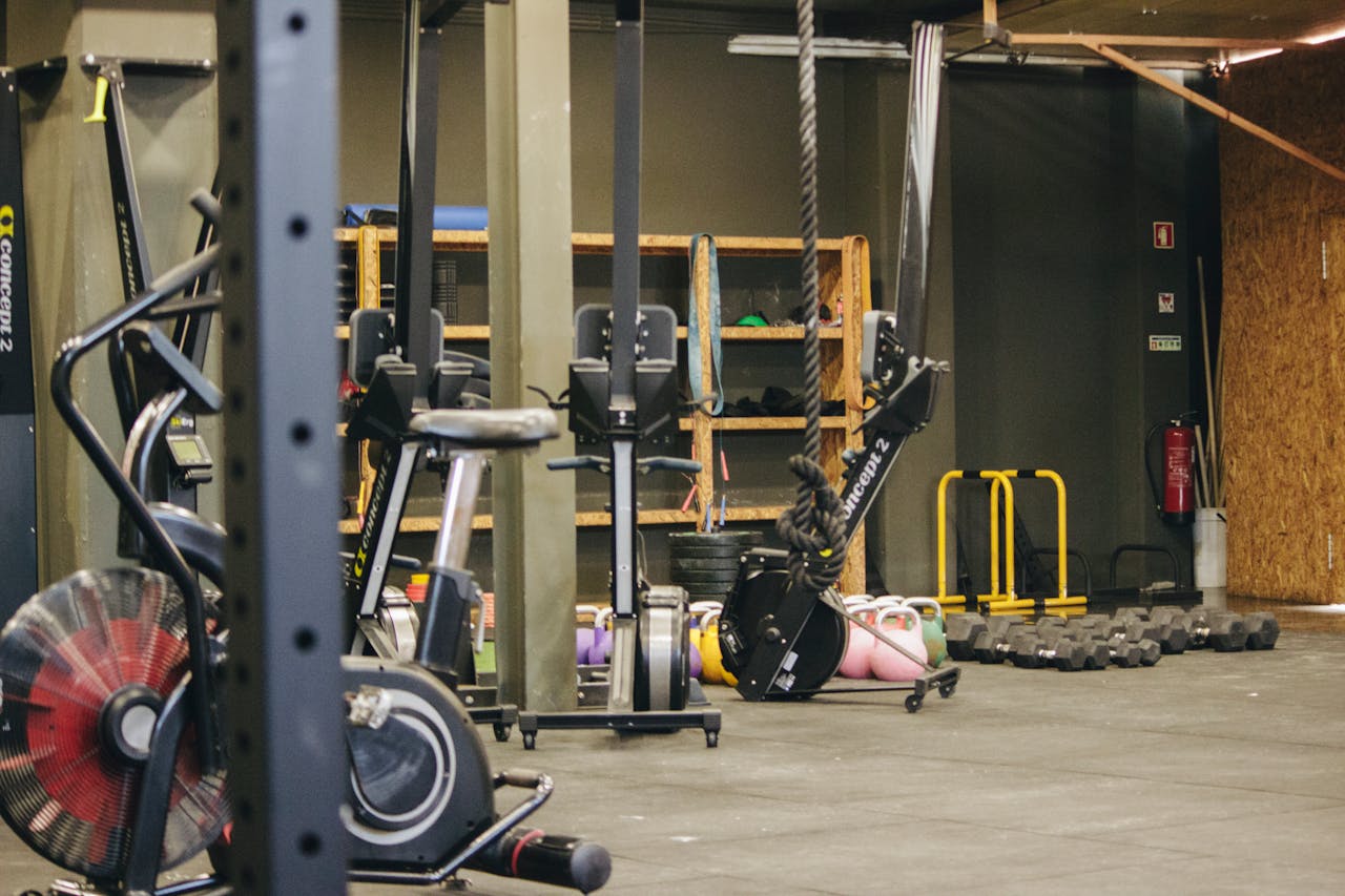 An indoor gym with various exercise equipment and weights ready for workout.
